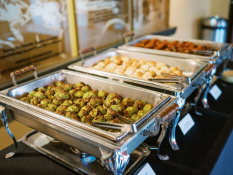 A buffet with 3 chafing dishes with the focus on spinach and artichoke stuffed mushroom caps