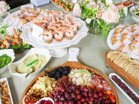 A table with an array of DailyDish catering menu options, including a charcuterie board, strawberry salad cups, and cilantro lime shrimp