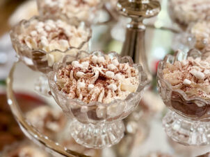 A close-up view of creme de pot desserts in crystal goblets on a three-tier glass serving dish